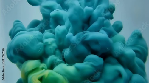 Abstract swirls of teal and lime green ink diffusing in liquid