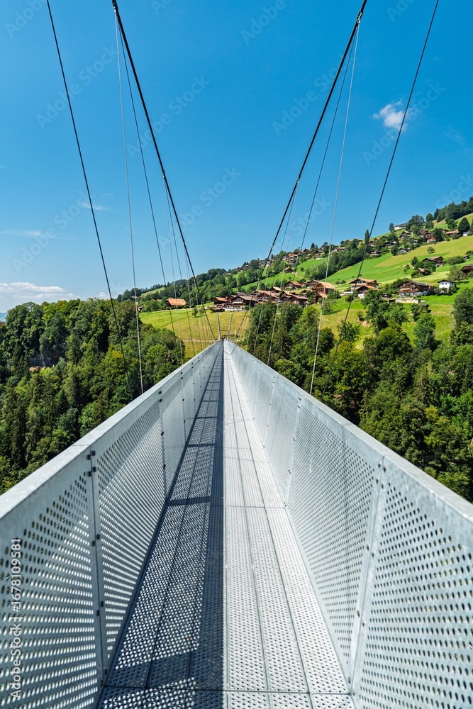 Obraz premium Walk across a breathtaking suspension bridge in Switzerland, Canton Bern. Experience stunning views and unique designs perfect for tourism and adventure promotions.