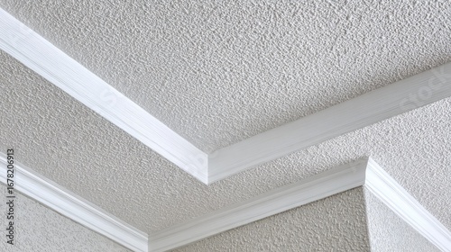 Interior corner of a room with textured ceiling and white trim.