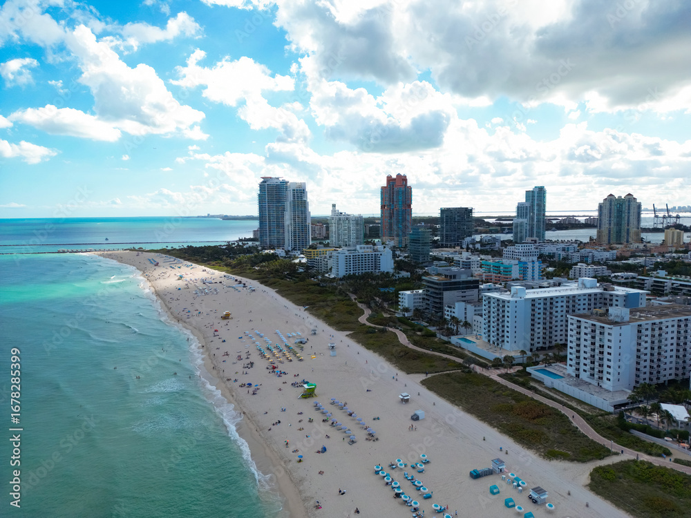Naklejka premium Beach in Miami with sunbed on a sandy beach with ocean waves. Miami Beach paradise with stunning views. South Beach Miami lifeguard post. Peaceful seaside retreat in Miami. Coastal relaxation.