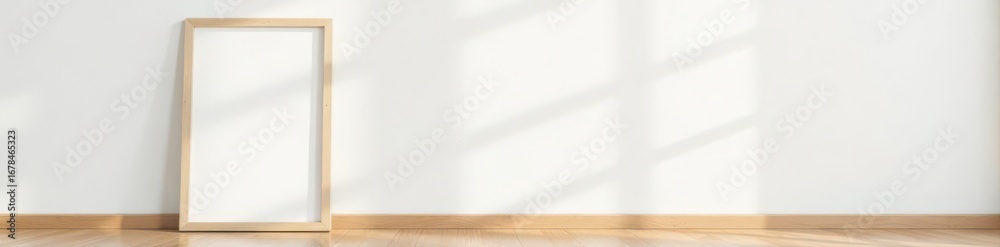 Obraz premium Empty light wood frame leans against white wall on wooden floor , empty, art