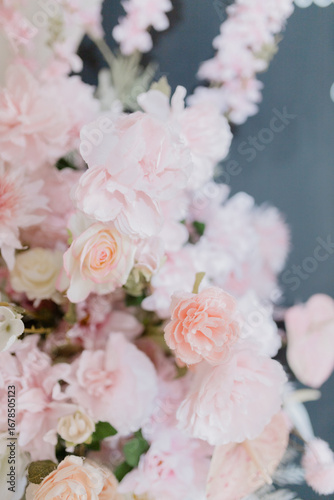 A beautiful close-up of delicate pastel pink flowers, including roses and peonies, captured in soft natural light.