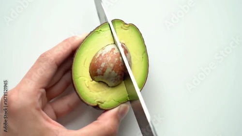 Satisfying Top-Down Slow Motion Video of a Knife Slicing a Ripe Avocado in Half