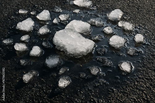 Melting Ice Chunks on Asphalt