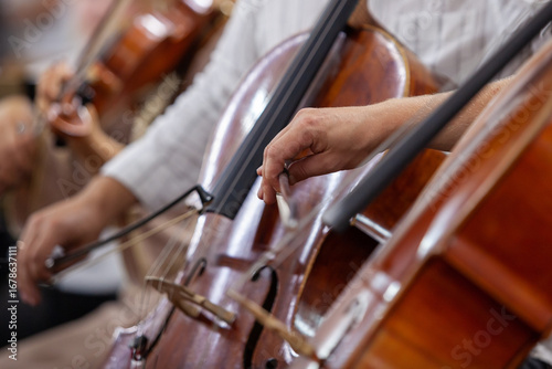 Hand of a musician playing the cello in an orchestra