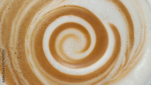 Pouring rich dark espresso into a creamy latte, creating a beautiful swirl of coffee and milk, perfect for a morning pick-me-up drink