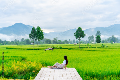 Canvas Print Young happy woman tourist enjoying and relaxing at rice paddy field while travel