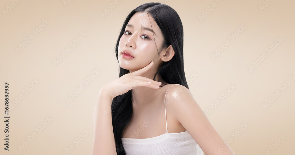 Fototapeta premium Close up perfect beauty face of young beautiful Asian woman posing gracefully with a soft smile isolated on brown background. Facial and skin care concept for commercial advertising.