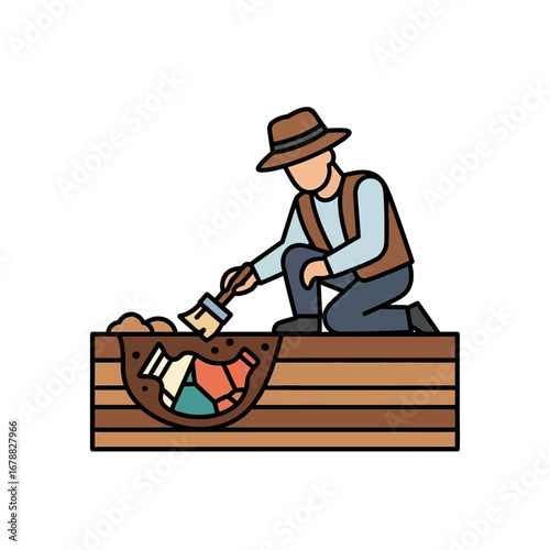 A person in a hat and vest carefully brushes dirt away from buried artifacts in an archaeological dig.
