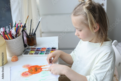 Healthy girl child painting with paintbrush indoor. Child 6 years old