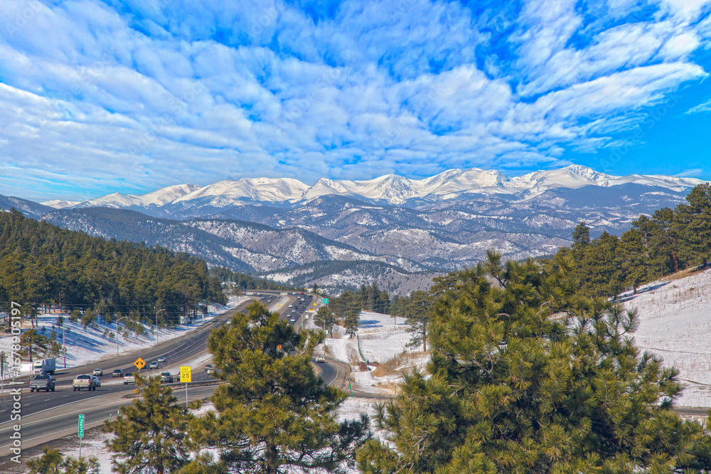 Obraz premium Scenic highway with Rocky Mountains peaks and pine forest