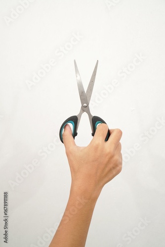 Female hands holding black scissors Isolated on white background. Closeup.