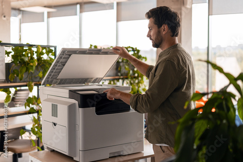 Office worker using multifunction printer in the office