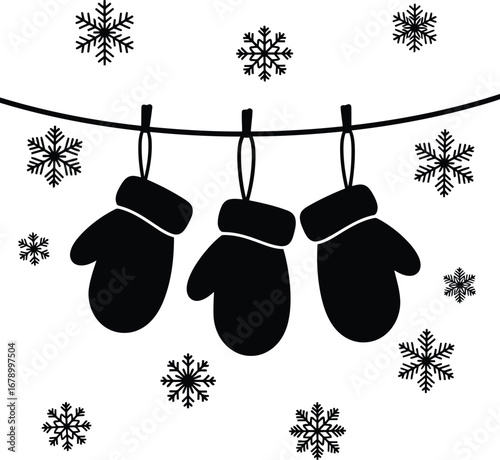 Three black mittens hanging on a clothesline with snowflakes falling around them.
