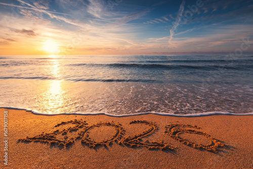 Happy New Year nature background concept, ocean sunrise and 2026 text on the beach sand and sea wave