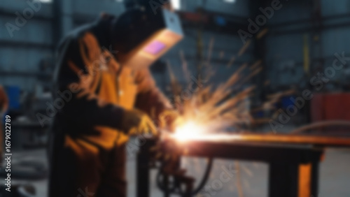 blurry image of someone welding iron, there are sparks, the person is wearing safety clothing, blurry wallpaper