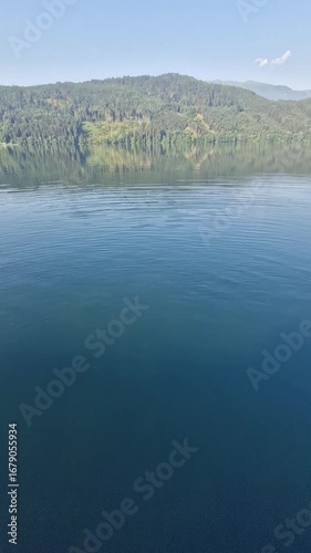 Serene misty lake scene in the morning with gentle ripples on the water.