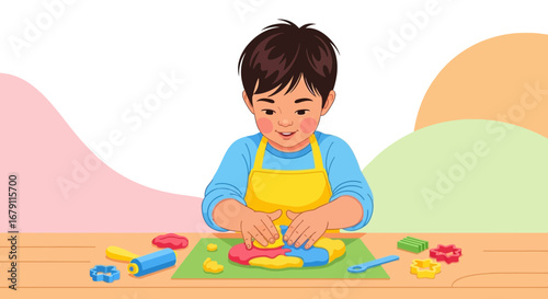 Young boy is happily playing with colorful clay and making shapes on a wooden table