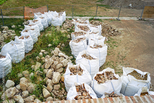 Принти на полотні Bricks collected in bags and a pile of stones lying next to them after restoration