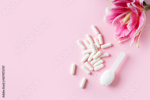 White Capsules and Collagen Powder on Pink Background