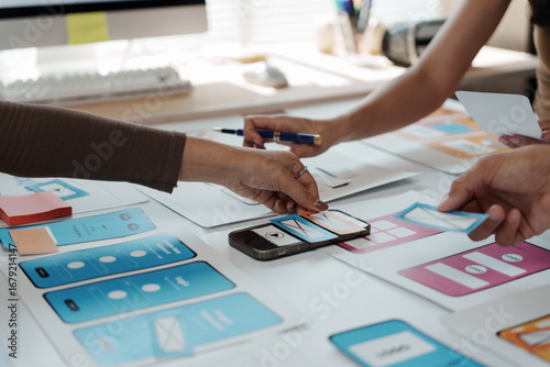 Fotografie User experience designers collaborating on a fresh mobile application template,