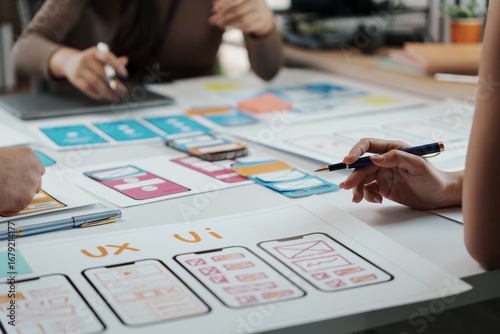 Valokuva Team of UIUX designers collaborating on a new mobile app, creating wireframes an