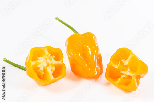 very spicy beautiful orange habanero pepper cut in half on white background
