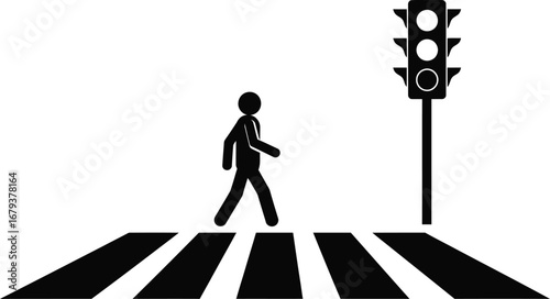 Silhouette of a person walking across a crosswalk at a traffic light