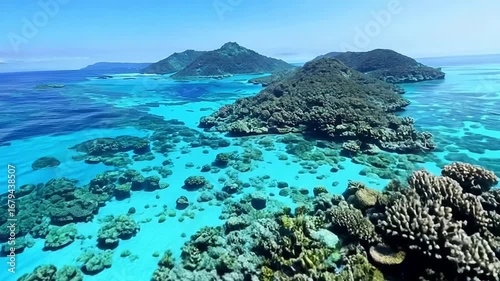 Aerial view of a tropical island with turquoise water and coral reefs.
