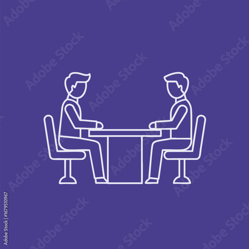Two individuals engaged in a focused discussion around a table, set against a simple, solid color backdrop