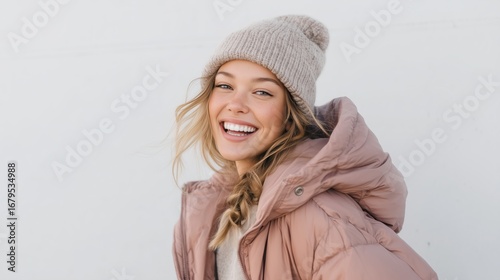 Smiling Young Woman in Winter Fashion Beanie and Puffer Jacket