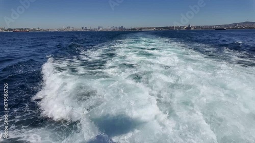 Cruise through clear blue waters with a stunning city skyline in the background on a sunny day