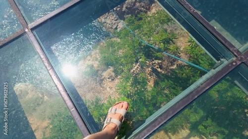 Walking on glass above stunning nature in a scenic location near water on a sunny day