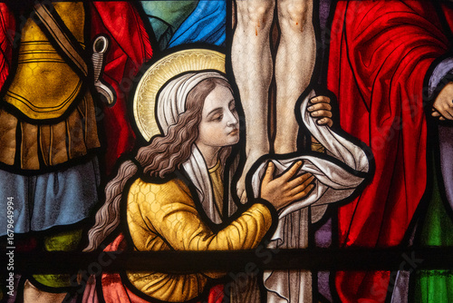 Bild auf Leinwand Stained glass (1914) of Saint Mary Magdalene at the feet of Christ on the cross