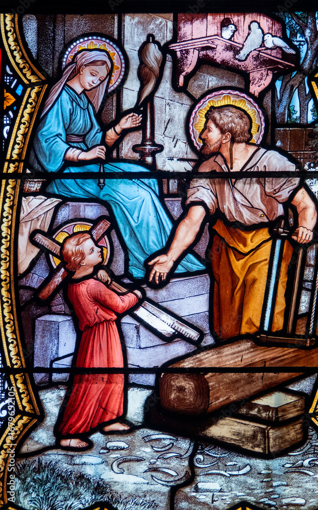 Fototapeta premium Stained glass (19th century) of Holy family: Jesus infant, Virgin Mary and St Joseph in the workshop of Joseph the carpenter.