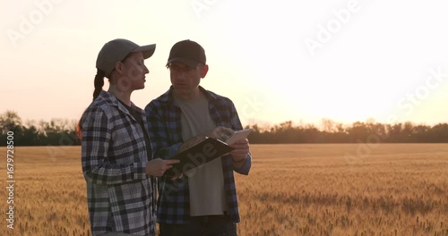 Two farmers in field discussing crop yield assessment. Assessment process uses digital tablet for accurate yield prediction. Sunset highlights teamwork during crop yield assessment.