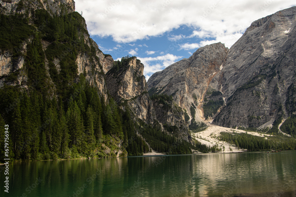 Obraz premium Photography of Lago di Braies, Italy, showing the turquoise alpine lake surrounded by mountains, pine forests, and scenic natural landscape in the Dolomites.