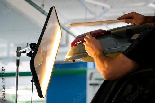 Canvas Print A professional mechanic is repairing a dent on a car's panel in an auto repair shop