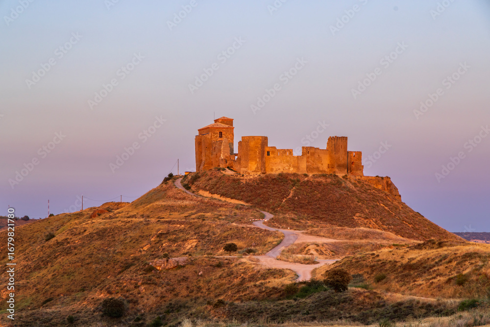 Obraz premium Castillo de Montearagon standing on a hill at sunset in Quicena, Spain