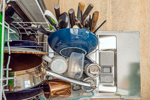 Tableau sur toile Metal dishwasher cavity with extended shelves, showing a haphazard arrangement o