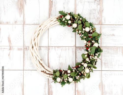 White wicker Christmas wreath on a white wooden background