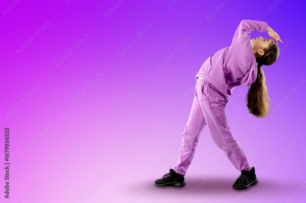 Naklejka premium Happy young girl dancing on color background
