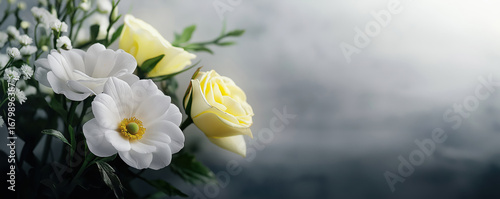 Funeral or memorial flowers featuring roses and daisies, with a dark, reflective background.