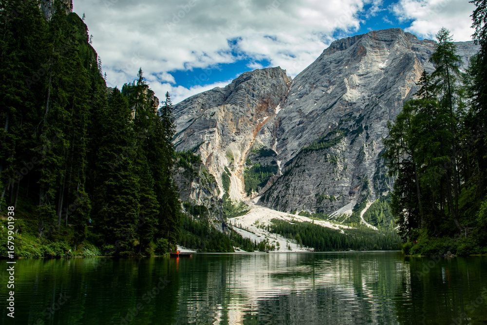 Obraz premium Photography of Lago di Braies, Italy, showing the turquoise alpine lake surrounded by mountains, pine forests, and scenic natural landscape in the Dolomites.