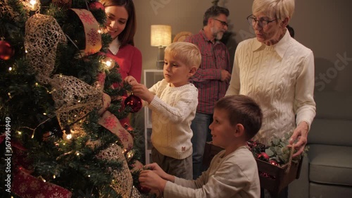 Family decorating christmas tree together at home