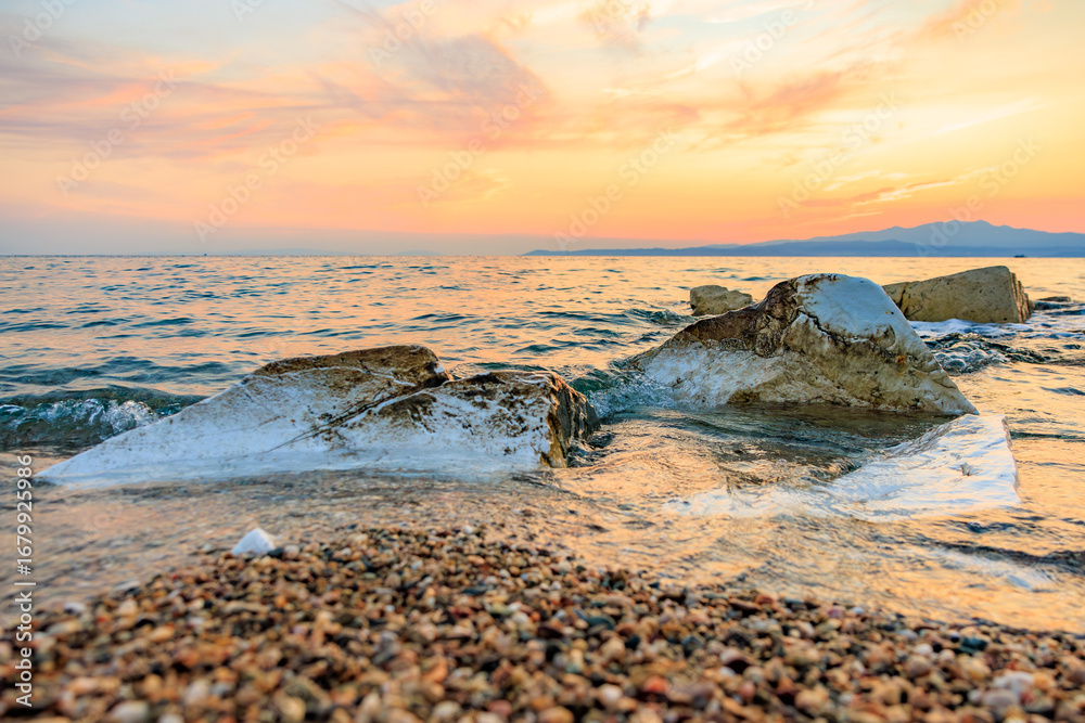 Obraz premium The ocean is calm and the sky is a beautiful orange color