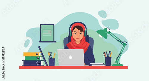 Focused professional woman in hijab and headphones works on laptop at her desk. Ideal for remote work, education, or online communication concepts.