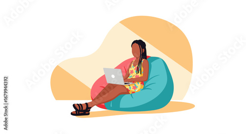 Young woman casually works on her laptop while sitting comfortably on a bean bag chair. Ideal for concepts of remote work, flexibility, and modern lifestyle.