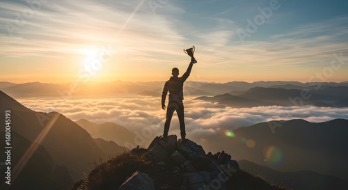 Victorious Person Holding Trophy on Mountain Peak During Sunrise