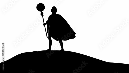 Silhouette of a cloaked figure holding a staff with a round top standing on a hill in black and white